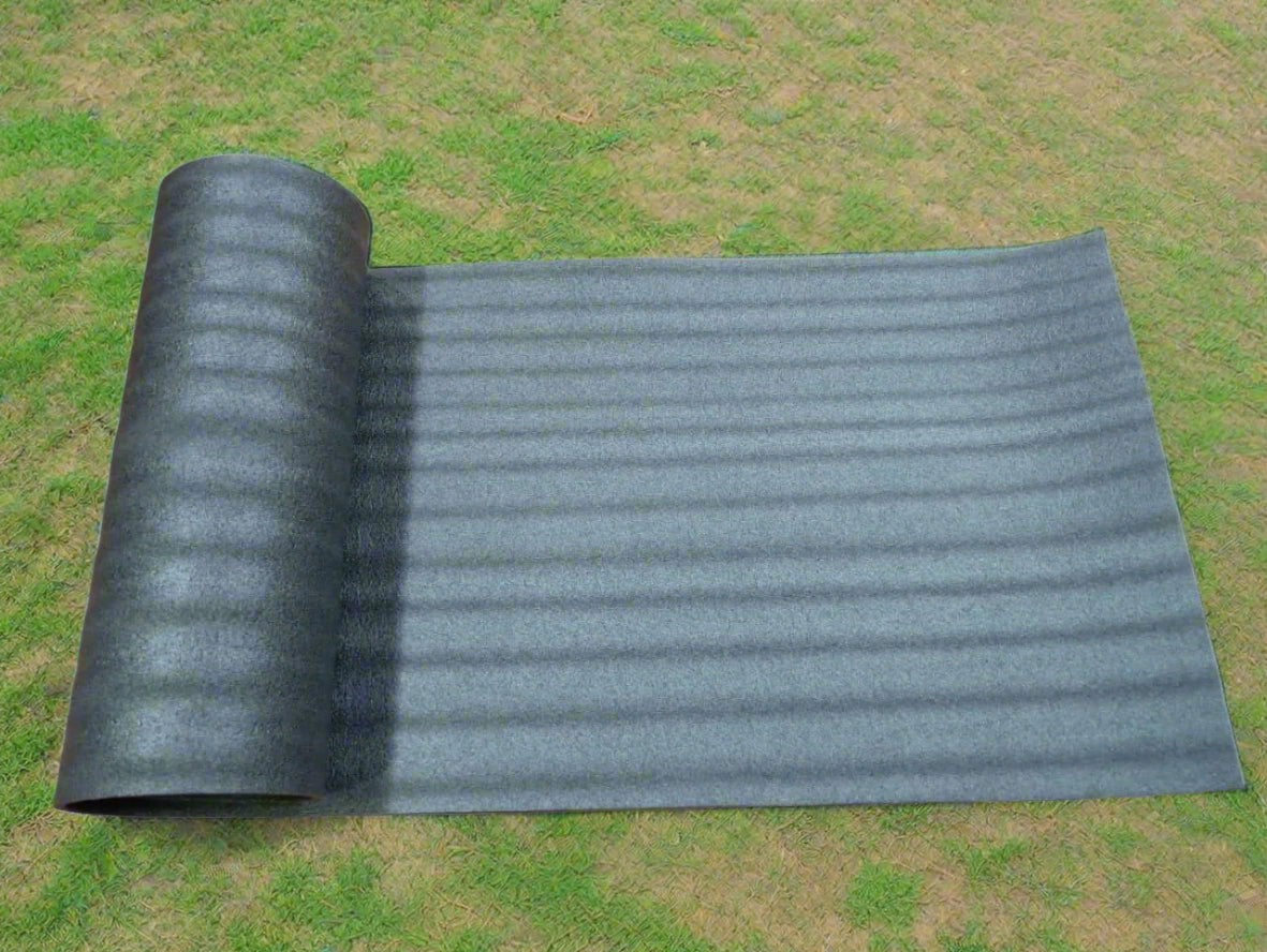 Roll of gray carpet on a wooden floor